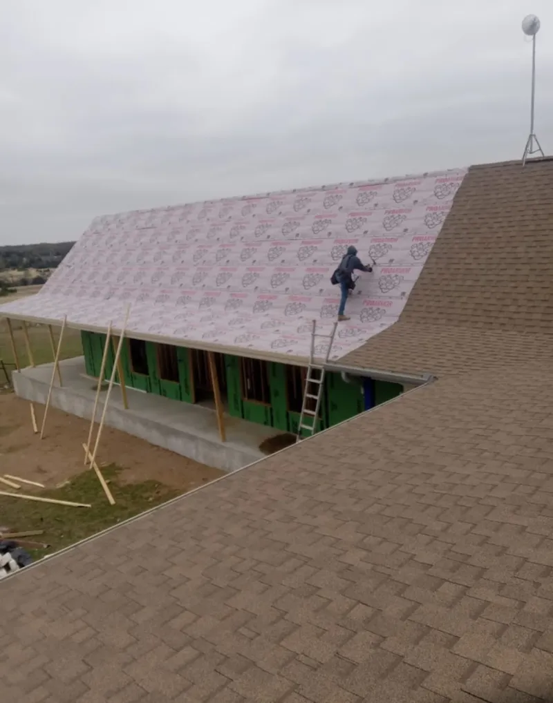 Worker preparing underlayment for a metal roof installation in Silver Spring